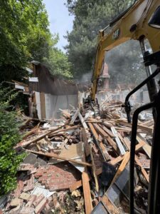 home being demolished by one stop dumpsters and demo in charlotte north carolina with an excavator
